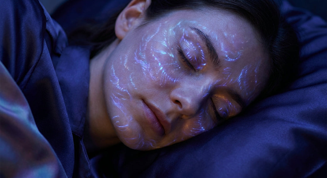 A woman sleeping peacefully in soft blue and violet bioluminescent light, evoking deep cellular repair and regeneration during sleep.